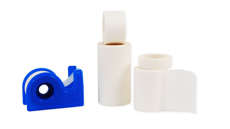 A blue tape dispenser surrounded by rolls of Sentry Paper Tape, a non-woven paper tape designed for surgical applications. Gentle on the skin with adequate adhesion to wound dressings, it promotes healing post-operatively while allowing the skin to breathe.